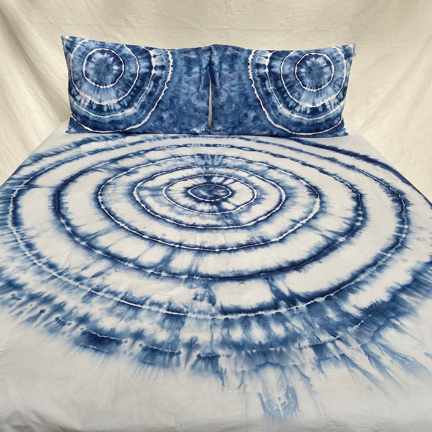 Tie-dye bedspread with circular patterns on a beige background
